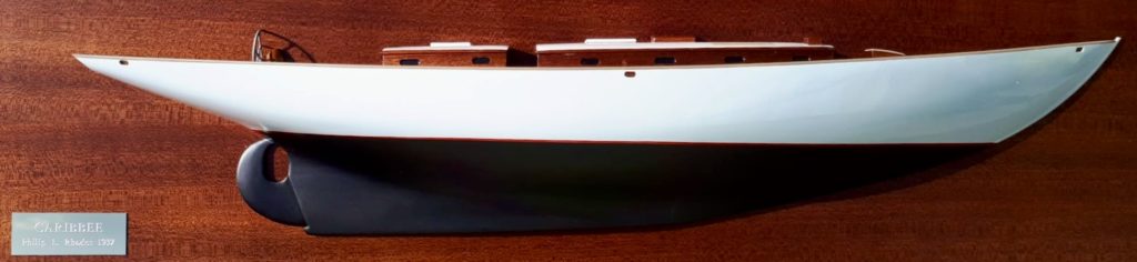 A half model of a ship mounted on a vertical wooden plate.