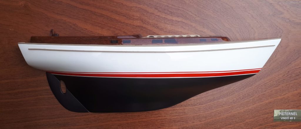 A half model of a ship mounted on a vertical wooden plate.